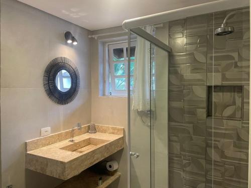 a bathroom with a sink and a glass shower at Chez Louise et Louis Pé na Areia in Juquei
