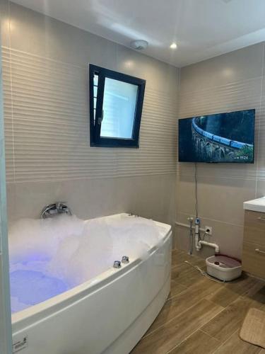 une baignoire dans une salle de bain avec une fenêtre dans l'établissement Villa piscine jacuzzi Montpellier, à Juvignac
