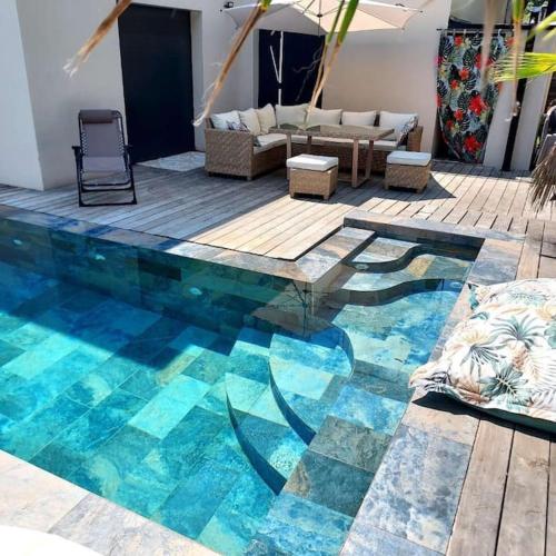 - un salon doté d'une piscine avec un canapé et des chaises dans l'établissement Villa piscine jacuzzi Montpellier, à Juvignac