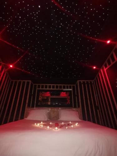 - une chambre avec un lit éclairé au plafond dans l'établissement love room paradix, à Saint-Denis-de-Pile