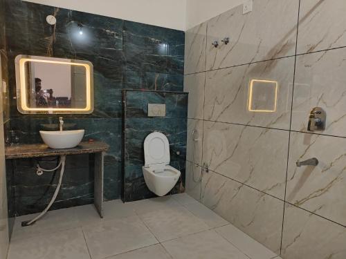 a bathroom with a toilet and a sink and a mirror at Veer Resort Jaipur in Wātka