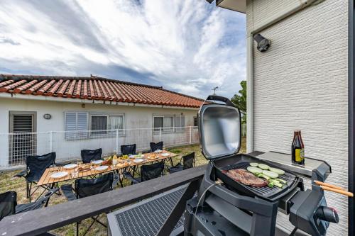 a bbq grill on a deck with a table at 1688House美ら海 in Motobu