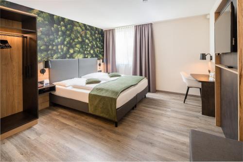 a hotel room with a bed and a desk at Best Western Hotel München Airport in Erding