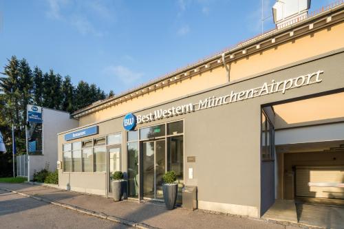 a store with a sign on the side of a building at Best Western Hotel München Airport in Erding
