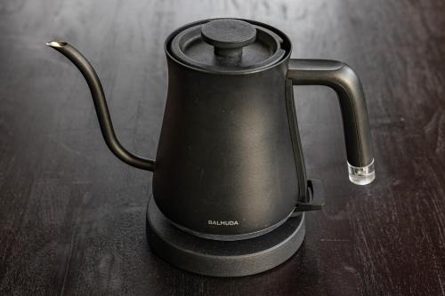 a black tea kettle sitting on a wooden table at 1688House美ら海 in Motobu
