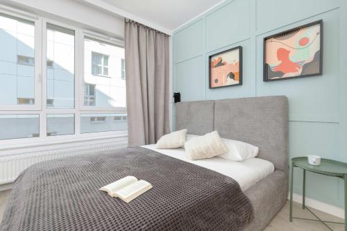 a bedroom with a bed and a large window at Studio Śląska z Siłownią w Gdańsku by Noclegi Renters in Gdańsk