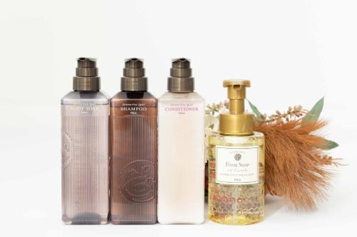 a group of three bottles of essential oils and a plant at 1688House美ら海 in Motobu