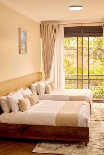 two beds in a room with a window at The beautiful Shams AO9 in Entebbe
