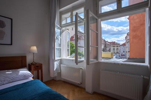 a bedroom with a bed and a large window at Charles Bridge Apartments in Prague