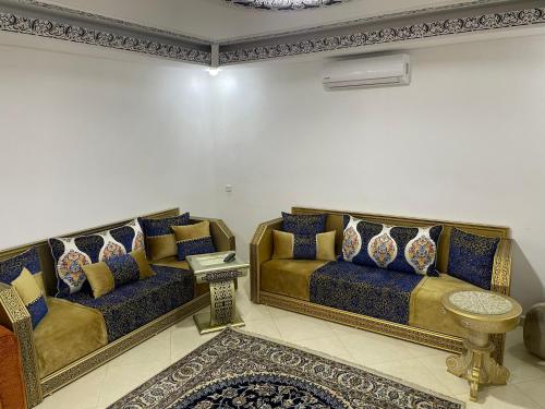 a living room with two couches and a table at Appartement RITZ in Tangier