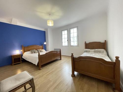 ein Schlafzimmer mit zwei Betten und einer blauen Wand in der Unterkunft Chocobia in Arbonne