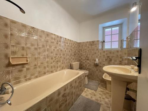 ein Badezimmer mit Badewanne und Waschbecken in der Unterkunft Chocobia in Arbonne