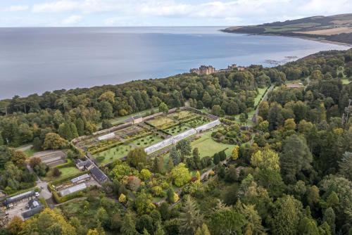 an aerial view of a castle on a hill next to a lake at North Firbank - Culzean Castle in Maybole