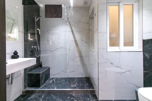 a bathroom with a shower and a sink at Spinola Seafront Deluxe in St. Julianʼs