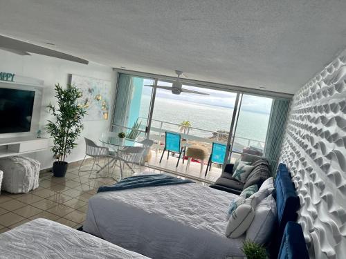 a bedroom with a bed and a view of the ocean at Beautiful Ocean Blue Love oceanfront apartment in Fajardo