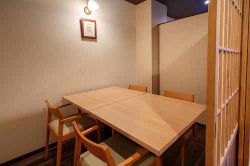 a dining room with a wooden table and chairs at Hita Onsen Kizantei Hotel in Hita