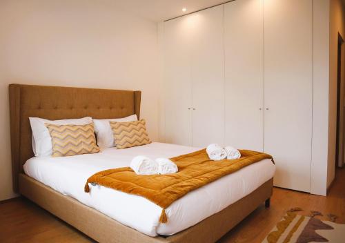 een slaapkamer met een bed met twee handdoeken erop bij Francos Family House in Porto