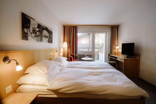 a large white bed in a hotel room at Alpine Hotel Perren in Zermatt