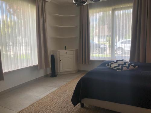 a bedroom with a bed and two windows at Puur17 in Lommel