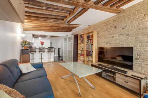 - un salon avec un canapé bleu et un mur en briques dans l'établissement Montorgueil City Center, à Paris