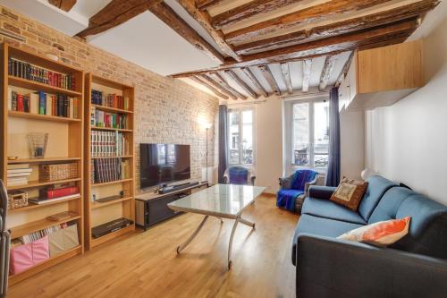 un salon avec un canapé bleu et une table en verre dans l'établissement Montorgueil City Center, à Paris