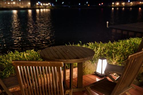 a table and two chairs sitting next to a lake at Hita Onsen Kizantei Hotel in Hita