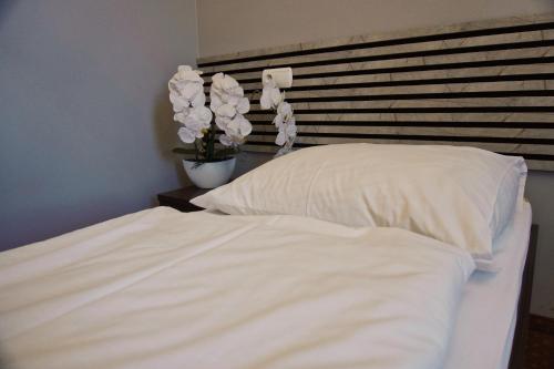 a bed with white sheets and pillows in a bedroom at Legnicki Browar Książęcy Hotel i Restauracja in Legnica
