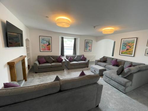 a large living room with couches and a television at Abergwaun Cottage in Fishguard