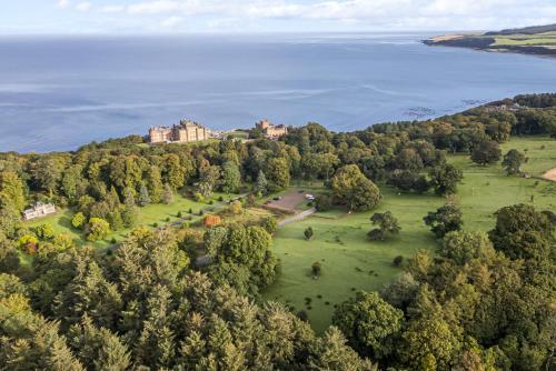 an aerial view of a castle on a hill next to the water at North Firbank - Culzean Castle in Maybole