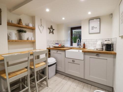 a kitchen with white cabinets and a counter top at The Snug on the Cobbles in Keighley