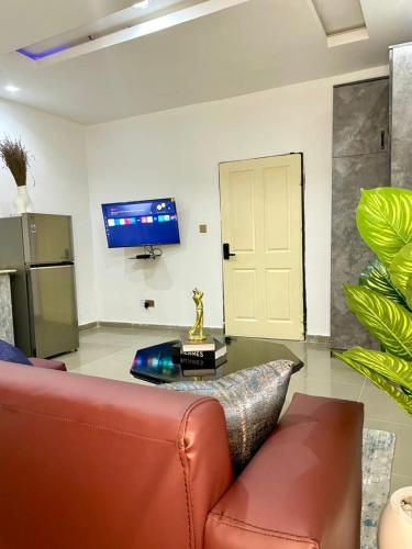 a living room with a couch and a tv at Wine House, Maitama, Abuja in Abuja