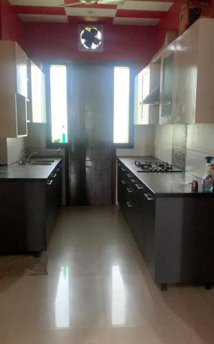 una cucina con elettrodomestici in acciaio inossidabile e mobili neri di Casa bello a Gurgaon