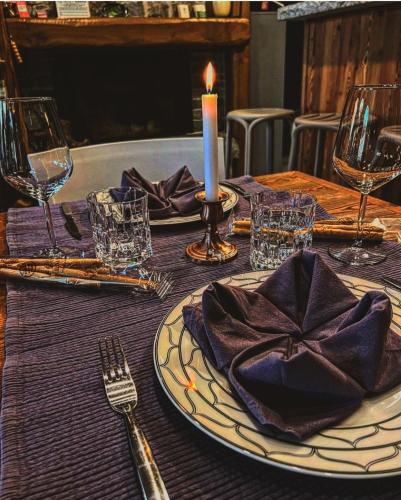 a table with a candle and a plate with a napkin at La Stella delle Alpi in Vico Canavese