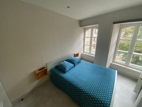 ein Schlafzimmer mit einem blauen Bett mit zwei Fenstern in der Unterkunft studio 5- les moulins in Cherbourg en Cotentin