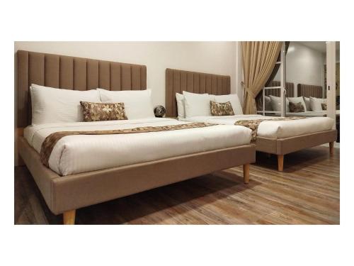 two beds in a room with two bedsitures at Buenaventura Suites in Calbayog City