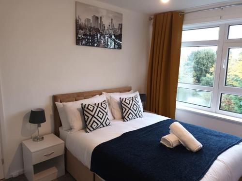 a bedroom with a large bed with a window at Jedid Kings Heath Apartment in Birmingham