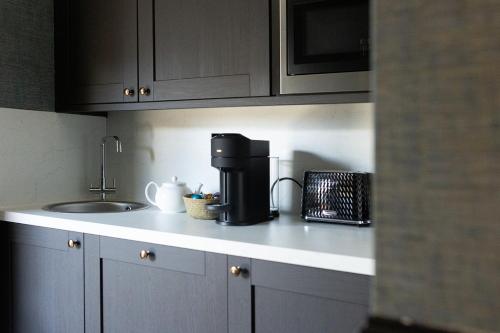 a kitchen counter with a coffee maker and a sink at Rob Roy - Self Check-In Boutique Accommodation in Berwick-Upon-Tweed