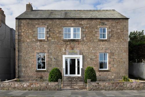 an old stone house with a white door at Rob Roy - Self Check-In Boutique Accommodation in Berwick-Upon-Tweed