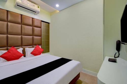a bedroom with a bed with red pillows at Super Collection O Snowfox in Kolkata