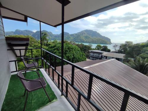 a balcony with two chairs and a view of the water at Kitty Guesthouse in Phi Phi Don