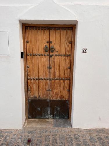 een houten deur aan de zijkant van een gebouw bij Preciosa casa con terraza in Vejer de la Frontera