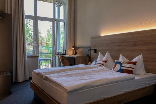 a bedroom with a large bed with a large window at Gästehaus am Lausitzring in Poley