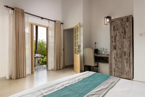 a bedroom with a bed and a desk and a table at Simpson's Forest - Luxury Boutique Resort & Spa - Kandy in Kandy