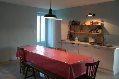 d'une cuisine avec une table et un chiffon rouge. dans l'établissement maison de campagne au bord de la mer, à Saint-Georges-de-la-Rivière