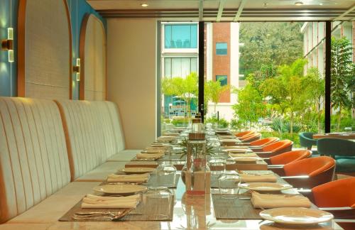 a long long table in a restaurant with chairs at Elements by Rosetta- Varca, Goa in Varca
