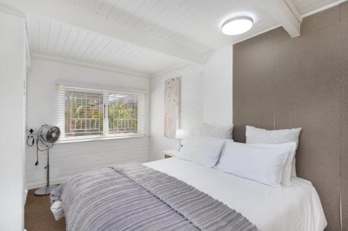 a bedroom with a white bed and a window at Sea View Hilltop Villa, Blouberg in Cape Town
