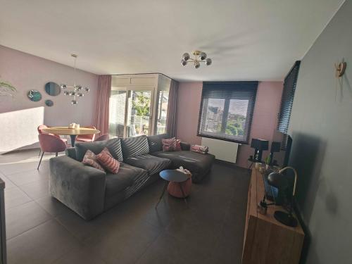 un soggiorno con un divano e un tavolo di Casa Rosa Leuven a Herent