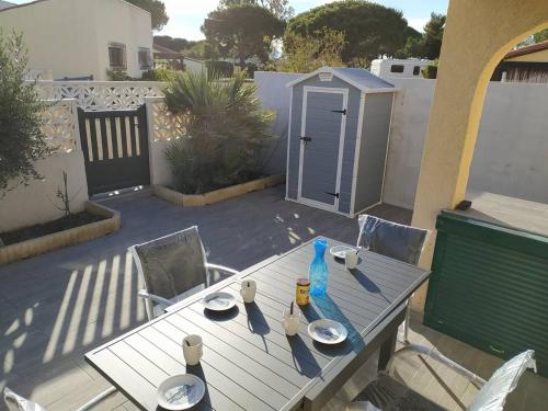 - une table de pique-nique avec des assiettes et des boissons sur la terrasse dans l'établissement Pavillon de vacances très bien équipé avec parking privatif - 6BRIGA7, à Saint Cyprien Plage