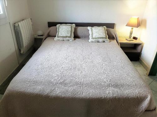 un grand lit avec deux oreillers dessus dans l'établissement Pavillon de vacances très bien équipé avec parking privatif - 6BRIGA7, à Saint Cyprien Plage