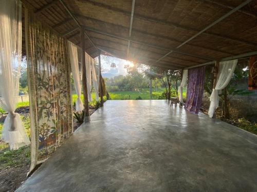 a large room with a concrete floor and curtains at Blue stone in Pai